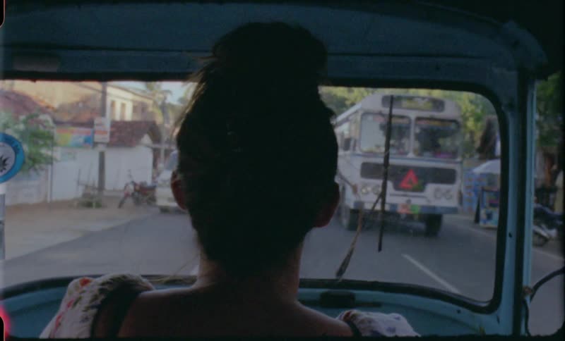 A female driving in a vehicle down a street in a small town