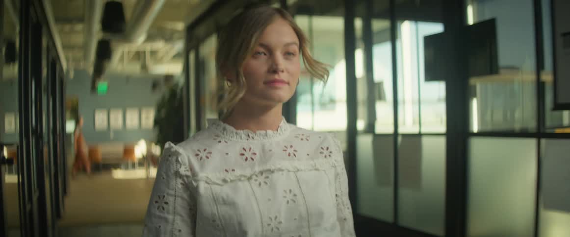 A woman is walking through an office building