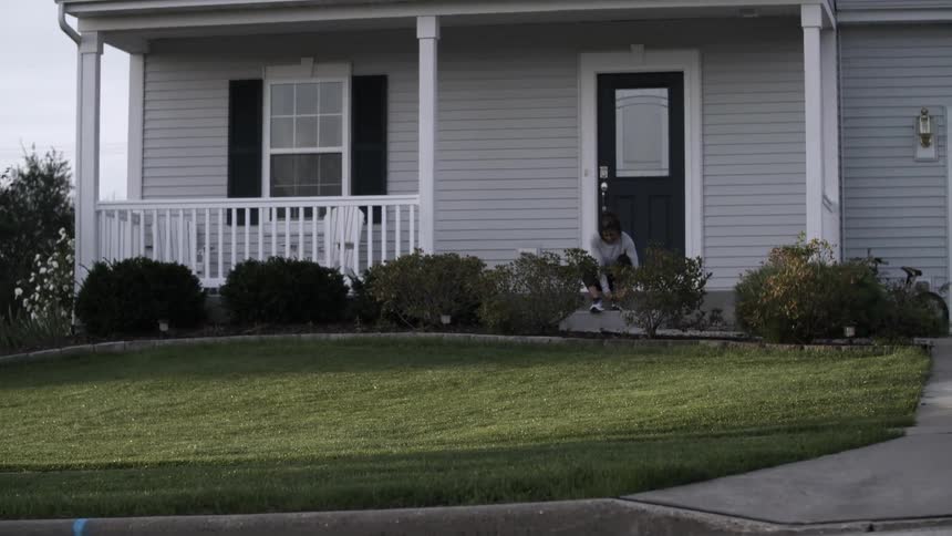 Black woman sitting on the doorstep ties shoe laces
