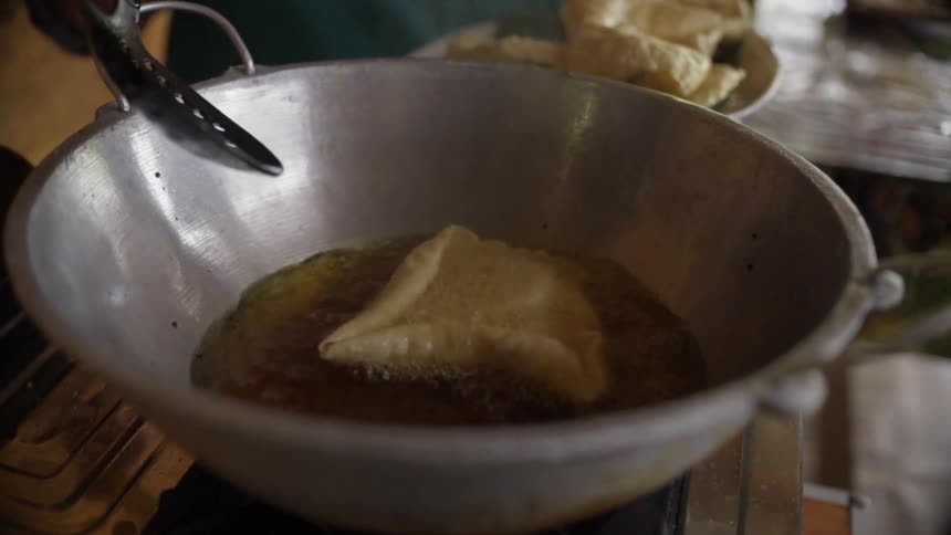 A person cooks a tortilla in oil at home