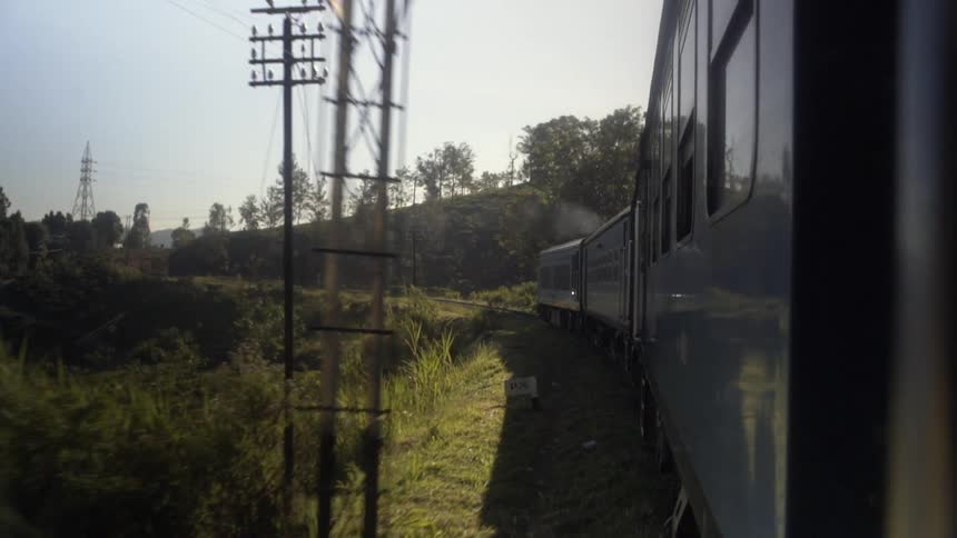 A train moving forward with trees and the sky in the background