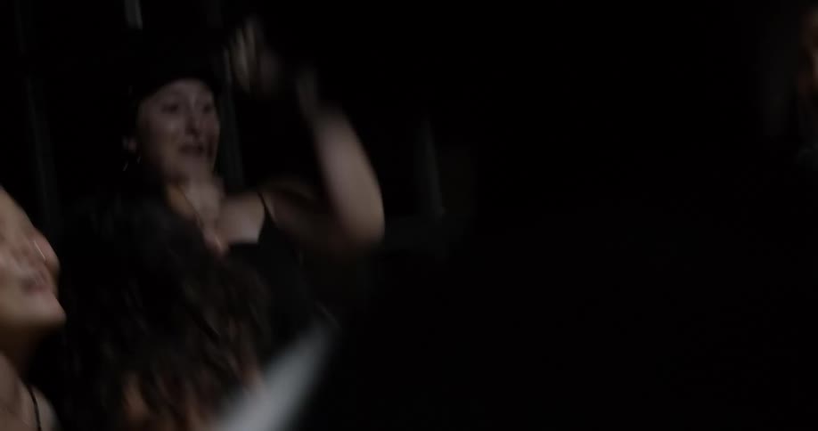 A group of people jump up and down as one sings into the microphone