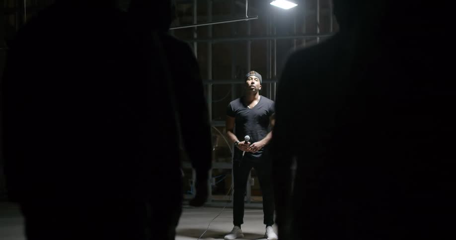 A group of people walk towards a man holding a microphone