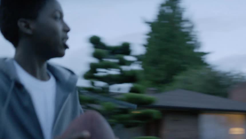 Teen boy in neighborhood street throws basketball