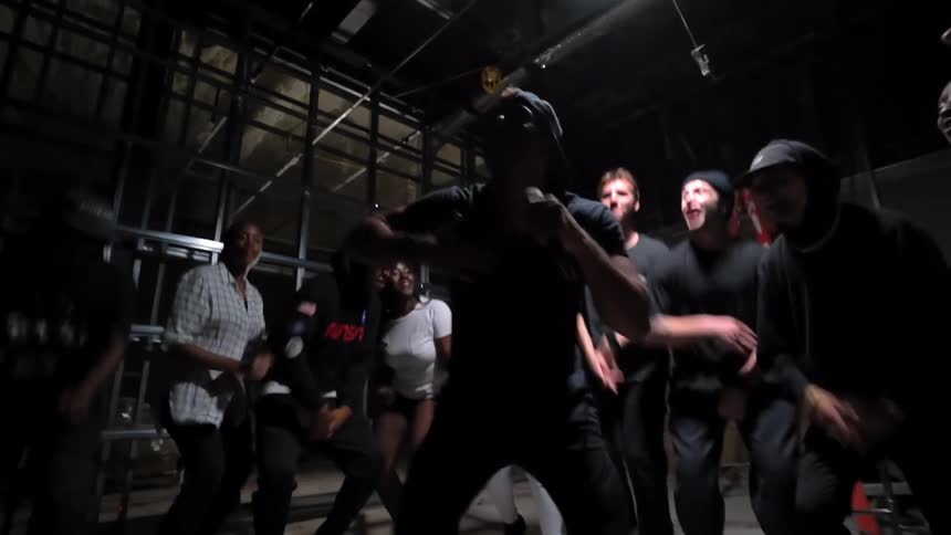 Man sings in cell as others listen and jump