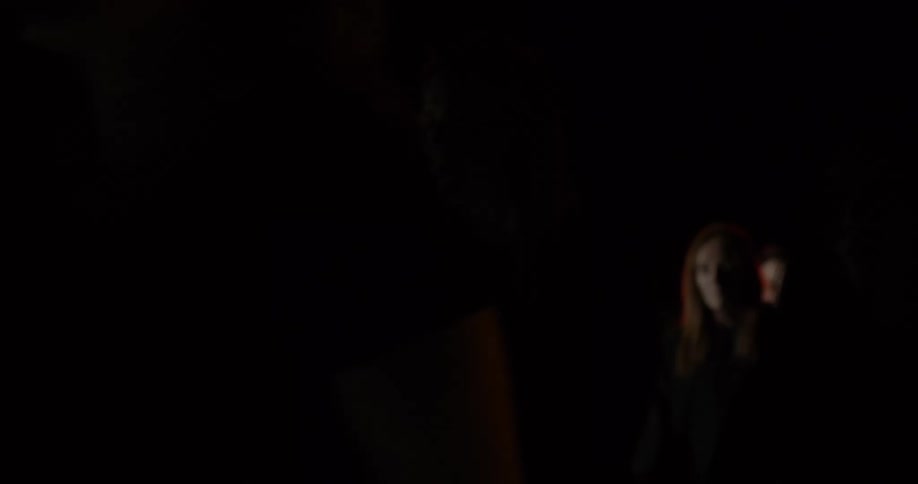 People with black shirts walking in the darkness
