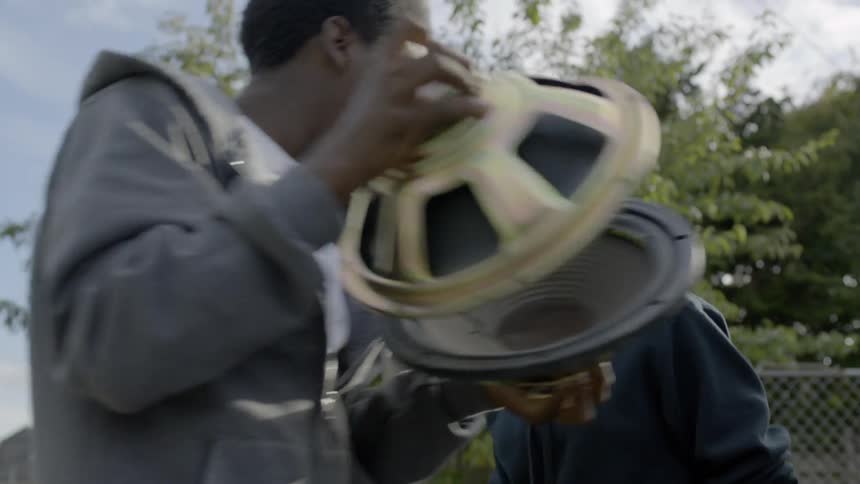 Three friends go around in a circle while clapping and banging items together