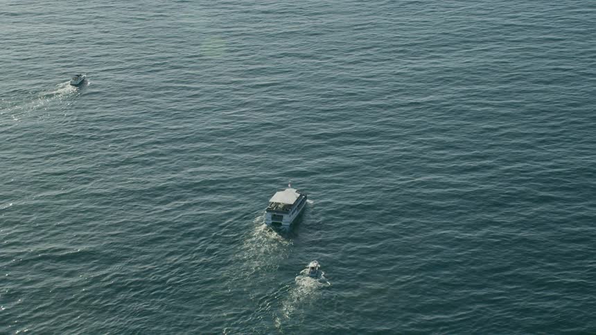 Three boats move across the ocean