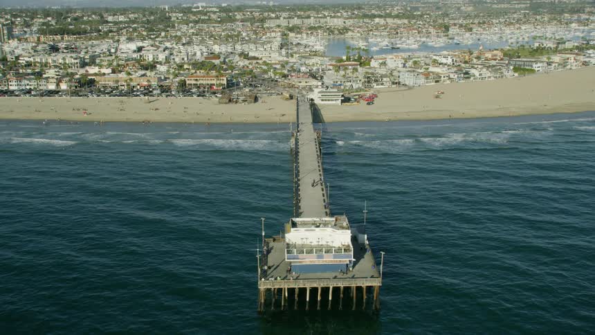 Flying over a pier in a southern California beach town