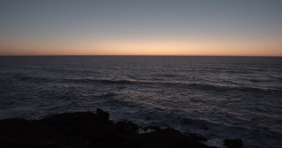 The sun is setting in the ocean
