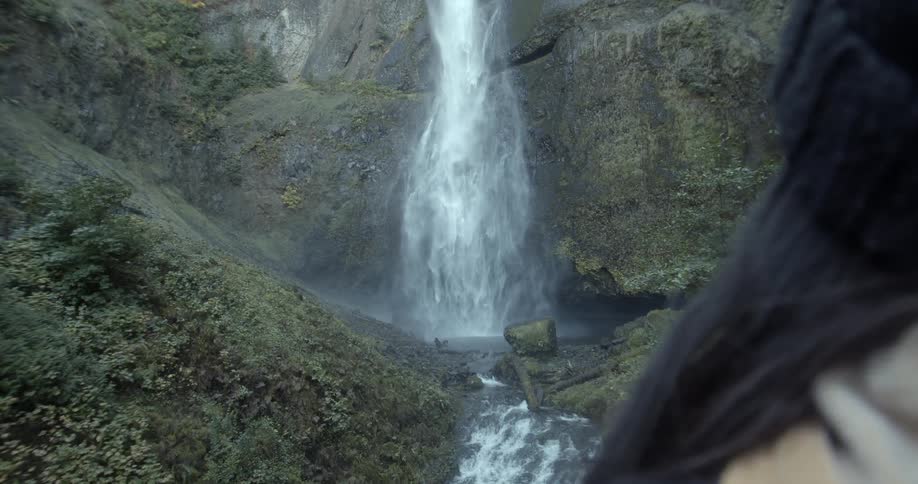Woman watches the foamy waterfall