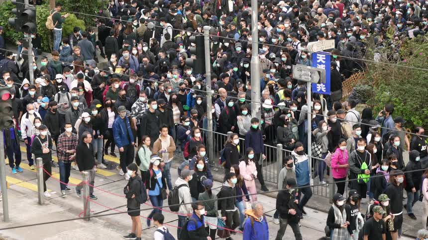 A large crowd of asian people walk through a maze of sidewalks