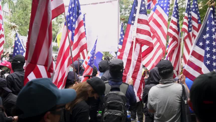 A large crowd of people holding flags