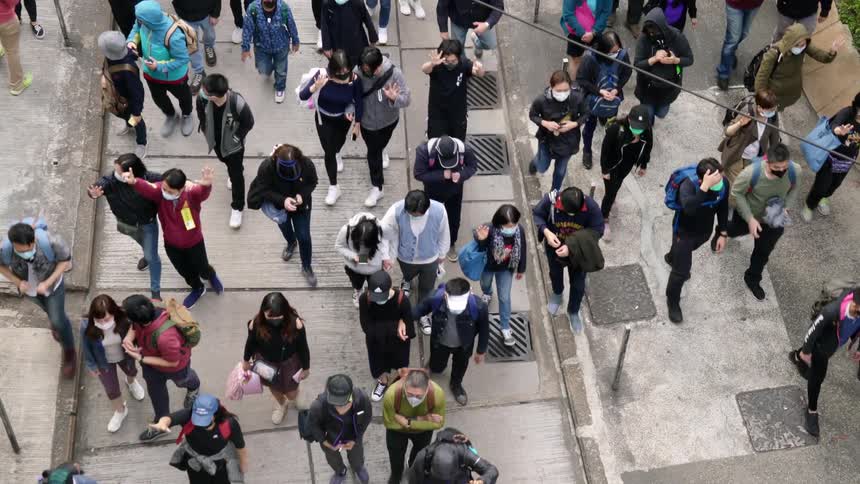 A group of people walk down a city street