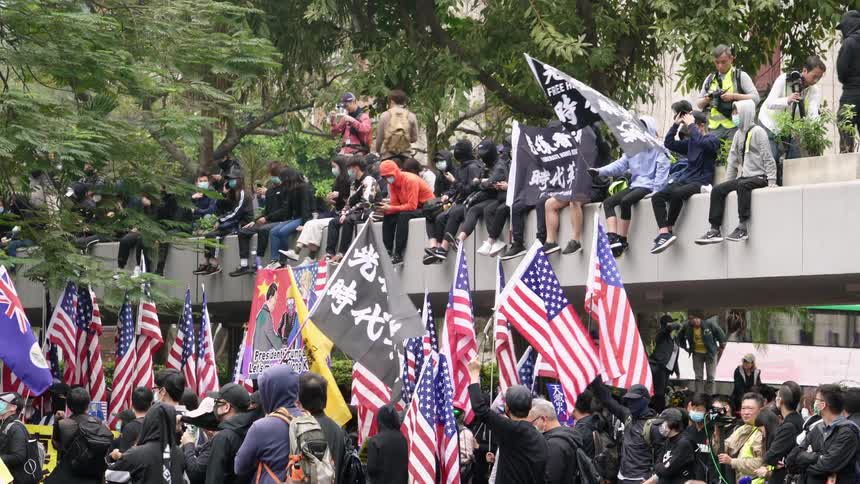 Group of protesters wearing facemask wave various flags on city