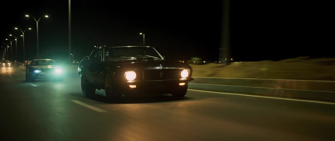 Sport cars driving on highway with headlights on at night