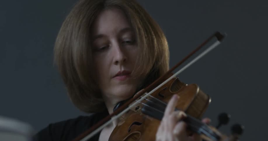 A woman is playing a violin