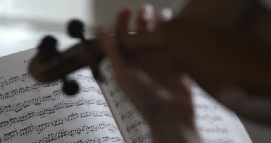 A music sheet sits in front of a playing violinist
