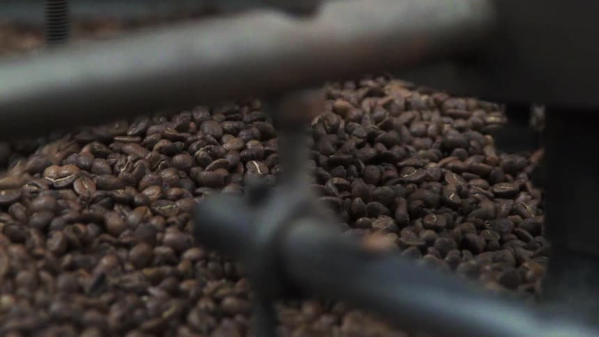 Coffee beans are being stirred in a large machine