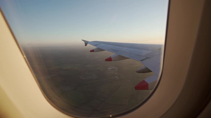 An airplane wing is seen from the window of a plane