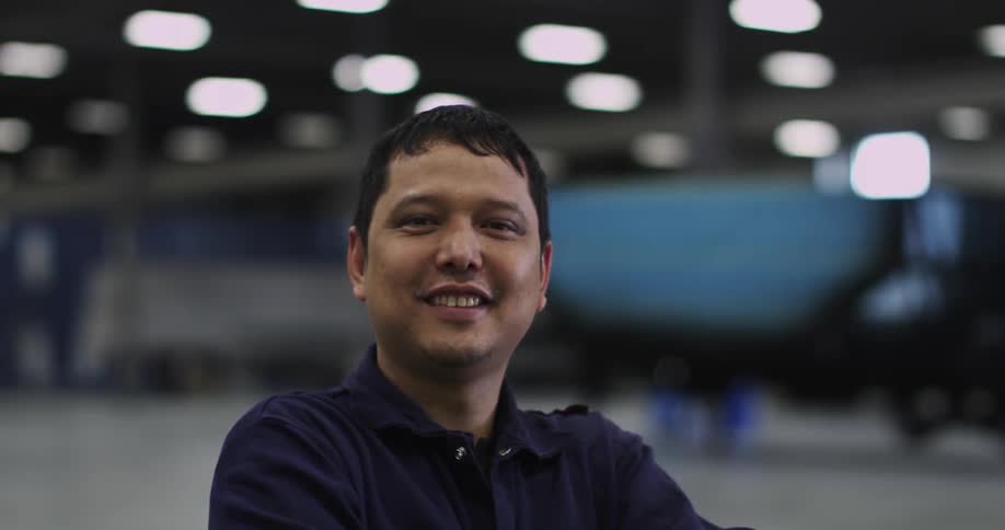 A man standing indoors smiles