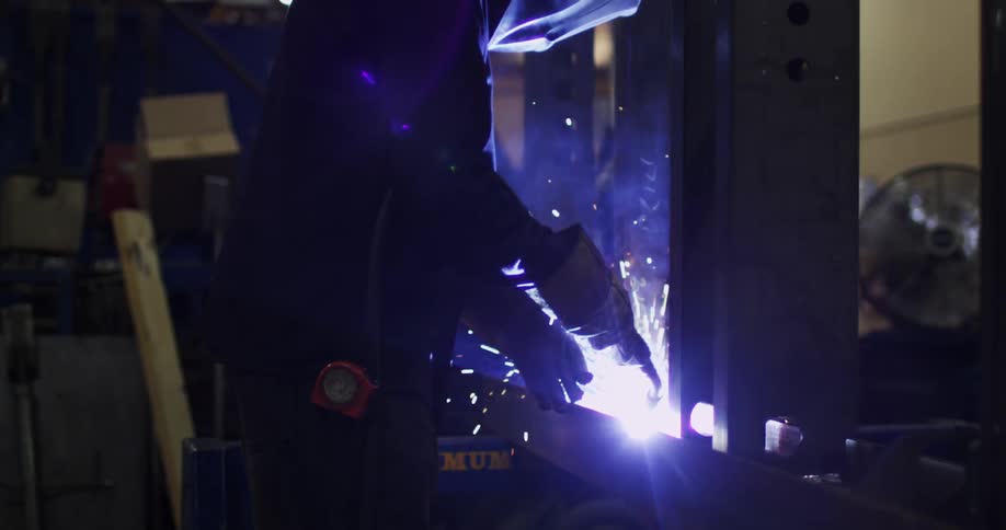 A man is welding inside a workshop