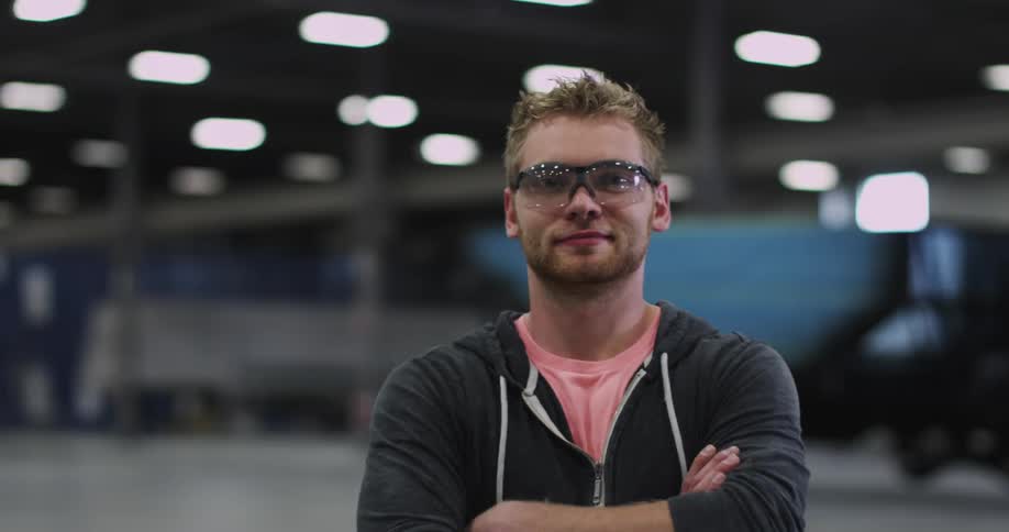 A man wearing goggles crosses his arms