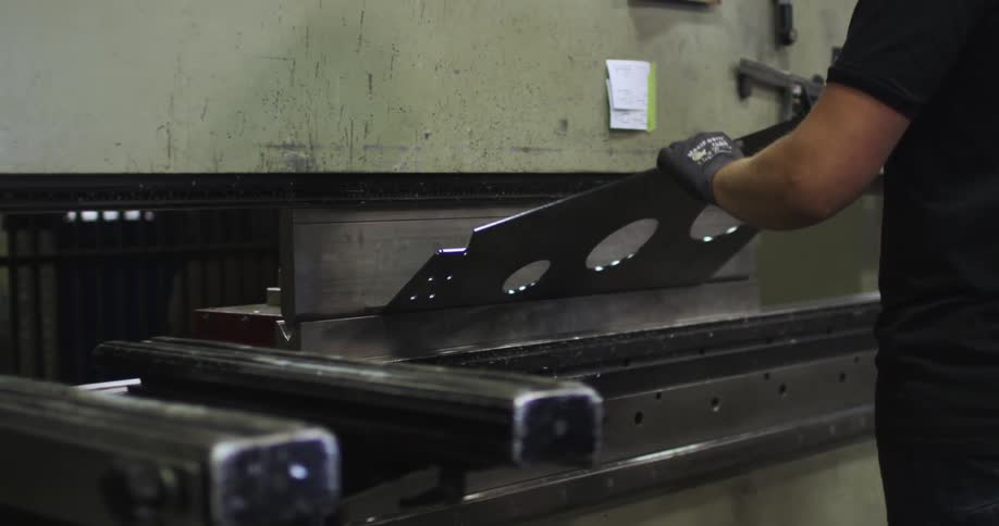 Man places metal in a cutting machine