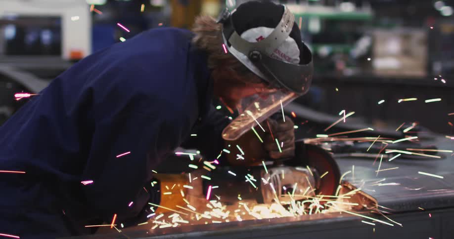 A man is using a circular saw in a warehouse