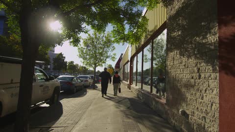 People walking down the sidewalk in an urban area