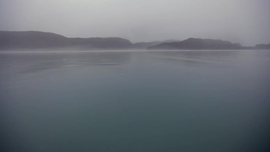 Traveling across still water on a foggy day