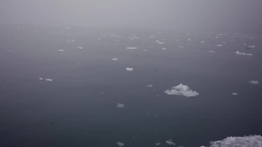 A boat is traveling in the water on a foggy day