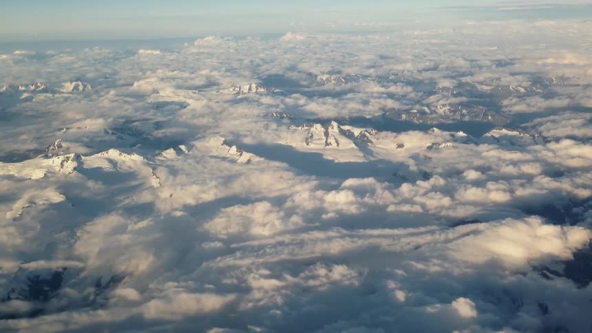 Clouds over icy and snowy mountains