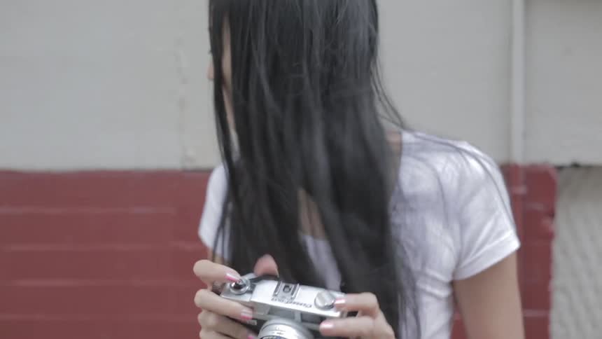 A woman is taking photographs in front of a building