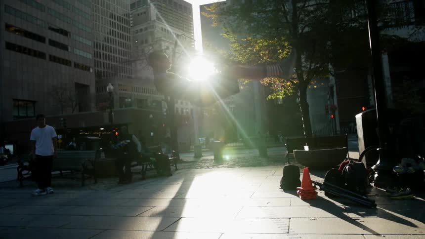 A man does a flip on a paved area