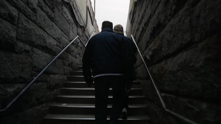 Two people climb up a set of outdoor stairs