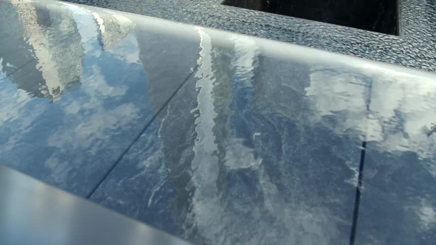Water in a pool or fountain shimmers and reflects buildings and clouds