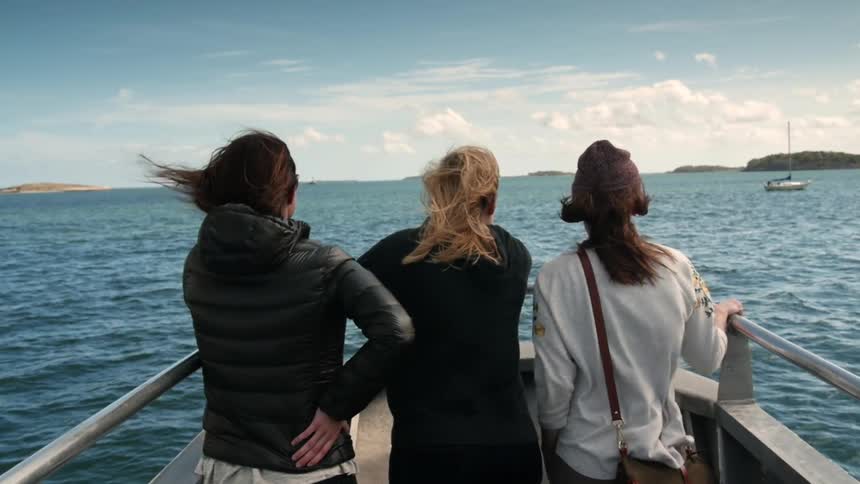Women ride near the front of a boat