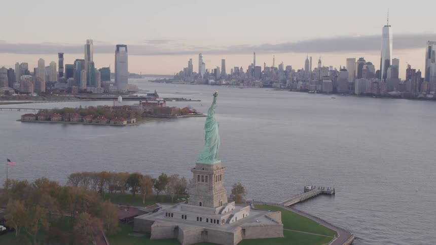 Statue of liberty on liberty island in new york harbor at sunset