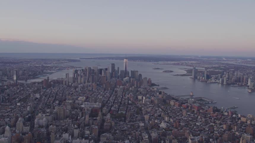Aerial view of the city skyline next to the river at dusk