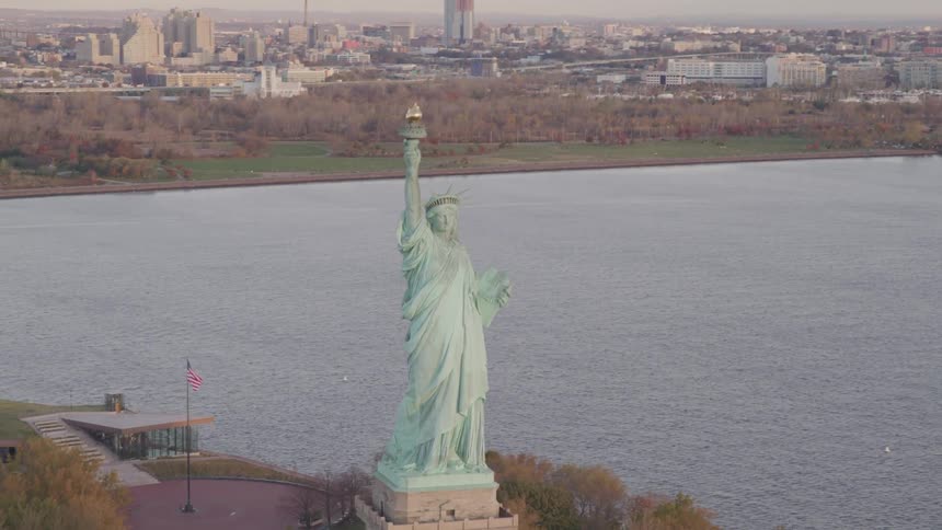 The statue of liberty is on an island by the city