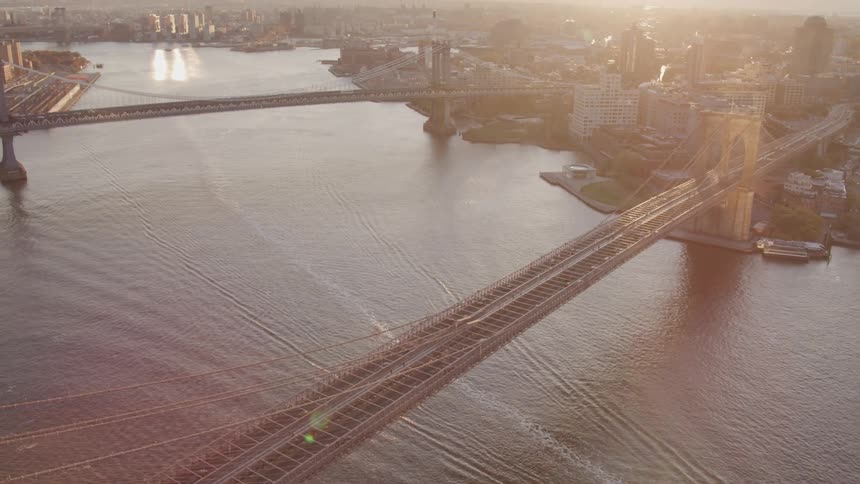 Aerial view of new york city with manhattan bridge and brooklyn bridge spanning the east river at sunset