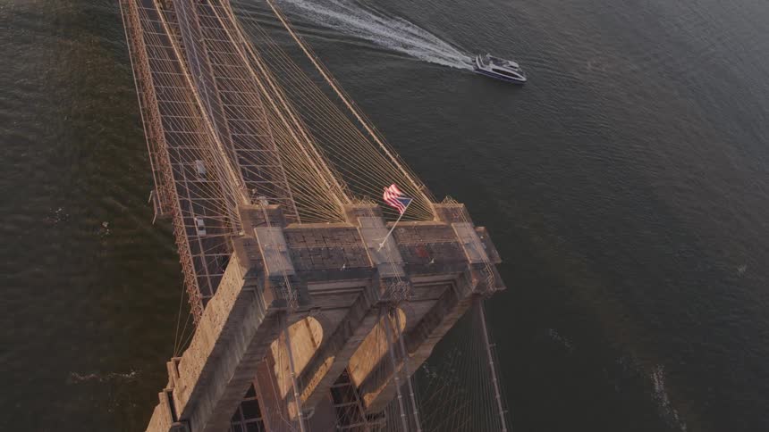 Boat passes near suspension bridge as traffic flows
