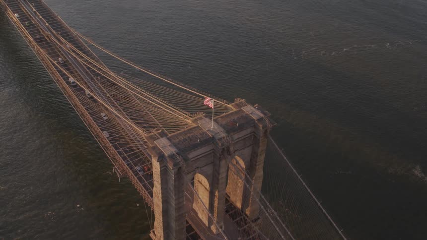 Aerial view of the brooklyn bridge on the river and a long line of vehicles crossing the bridge