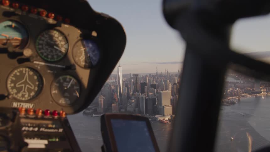A helicopter flies offshore of a large urban city