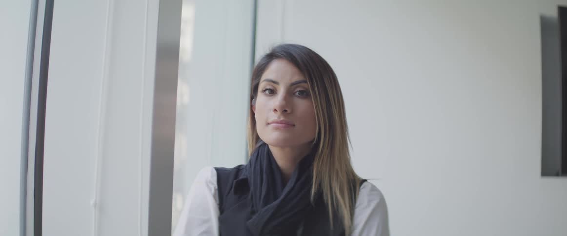A woman looking out a window then turns around and start staring