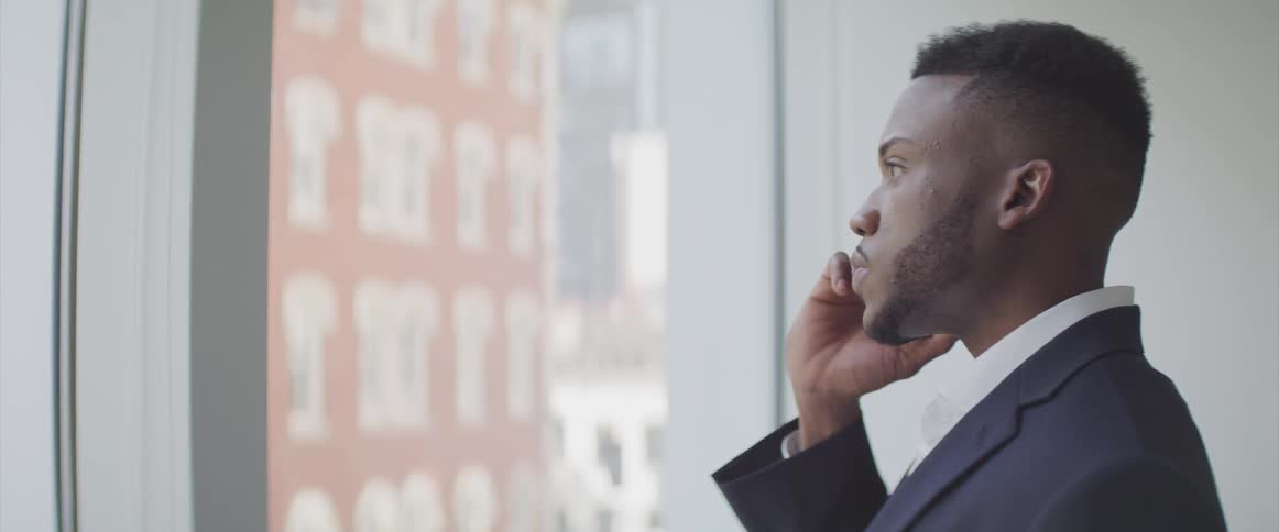 Black businessman speaks on the smartphone in the office