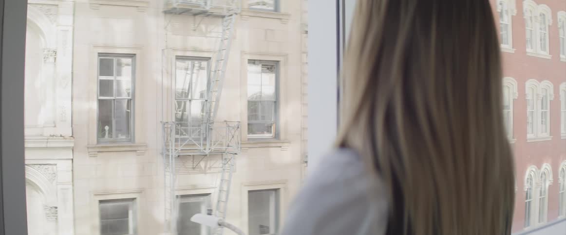 Businesswoman looks out the window in the office
