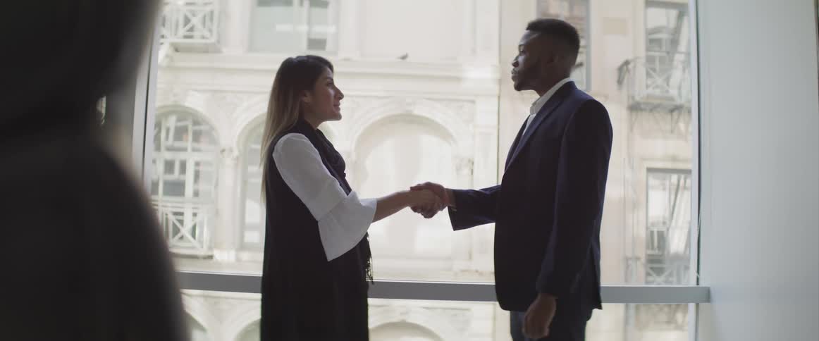 Businessman and businesswoman shake hands in the office