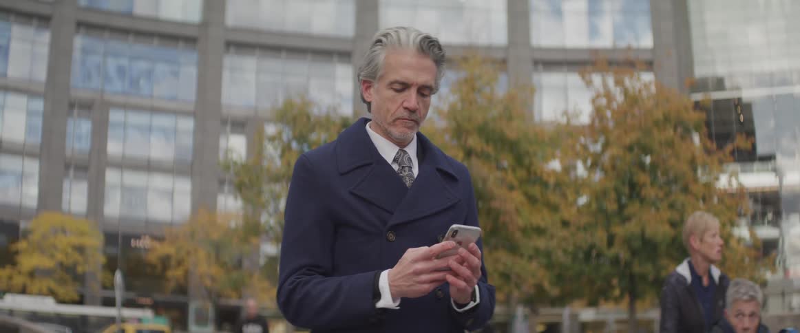 A man in a suit checks his phone
